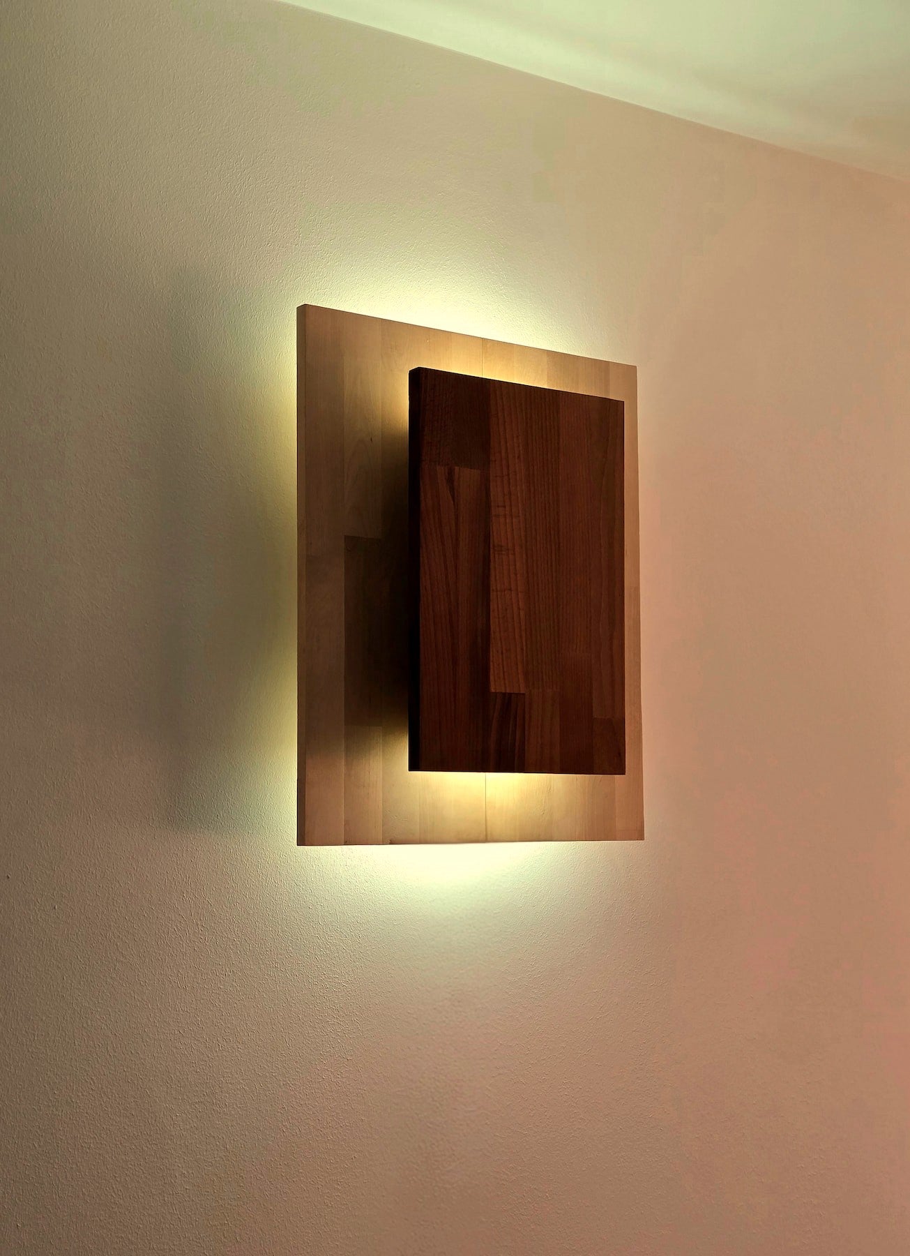 Applique Bouclier par Uphile, en essences contrastées, vue allumée face avant gauche