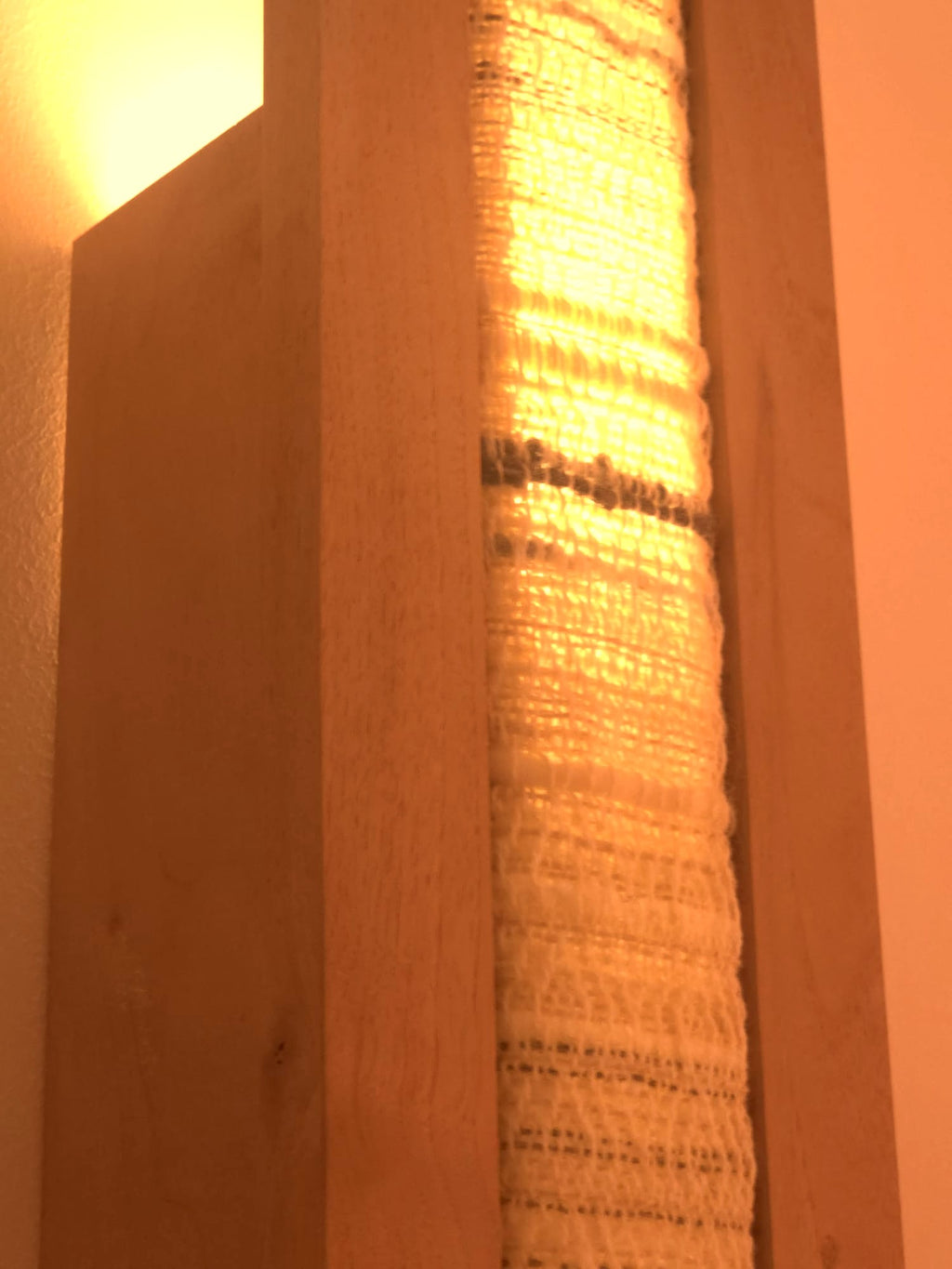 Applique Halo par Uphile, noyer et tissage sable, vue allumée avant gauche, détail centre.