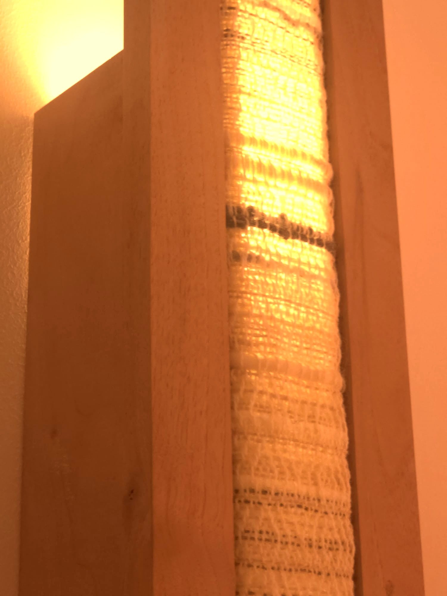 Applique Halo par Uphile, noyer et tissage sable, vue allumée avant gauche, détail centre.