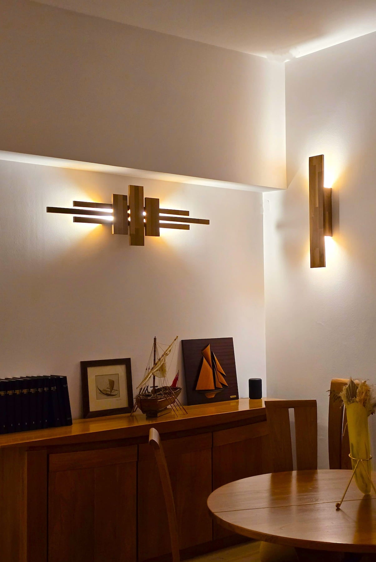 Appliques Syrca et flambeau de Uphile, vus allumés sur fond de mur blanc