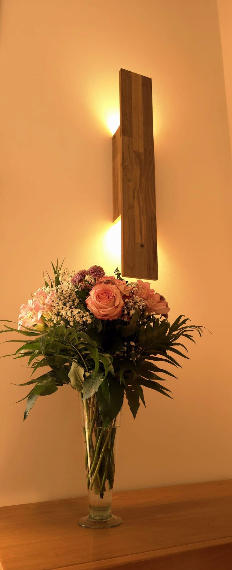 Applique Flambeau Uphile allumée vue avant gauche avec bouquet