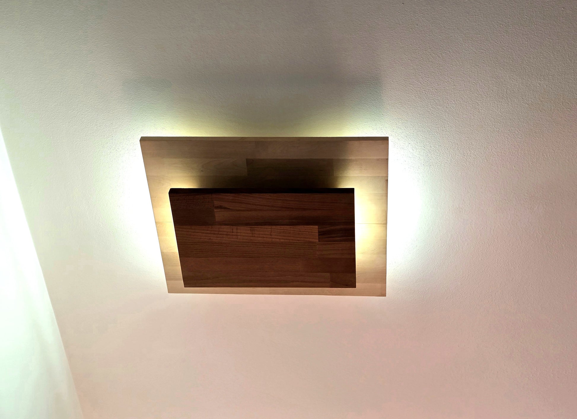 Plafonnier Bouclier par Uphile, en essences contrastées, vue allumé de dessous.